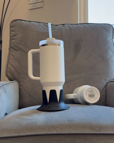 Two 40 oz tumblers on an armchair cushion, one seated in a black Steadi.